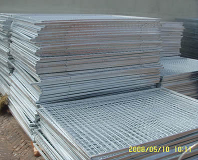 A pile of galvanized dog kennel panels on the ground.